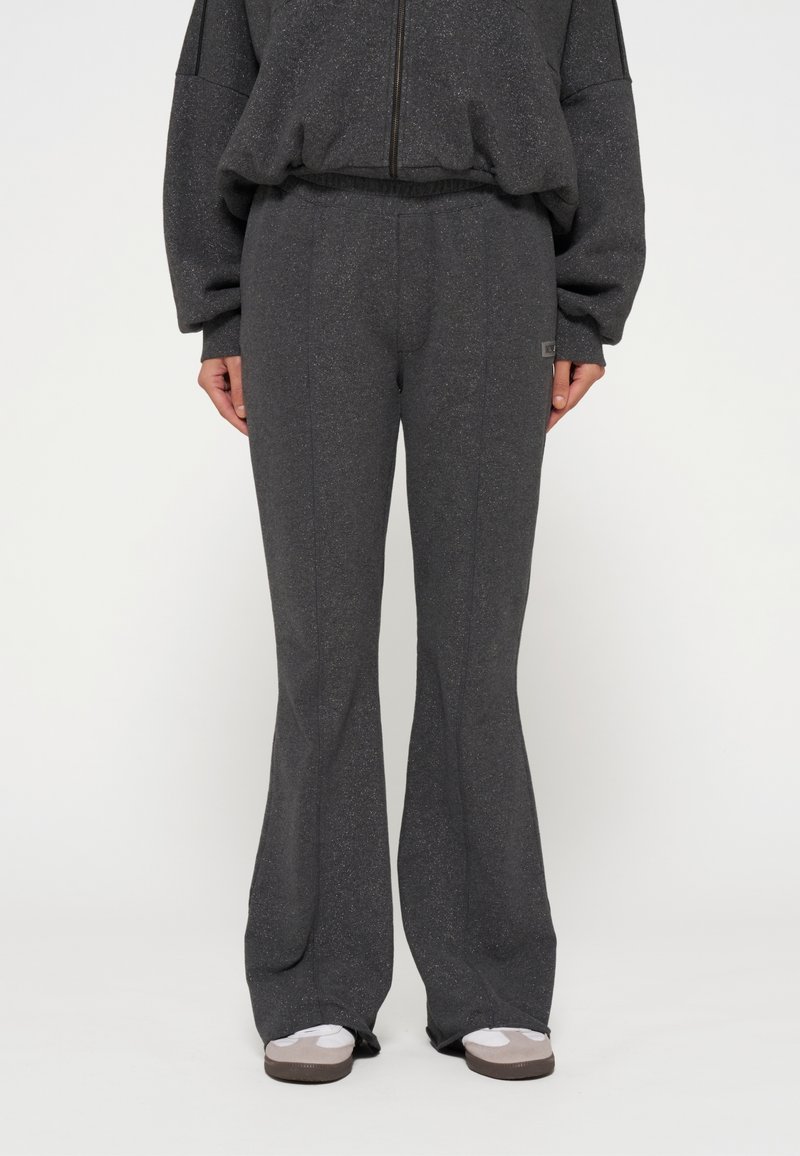 Grijze flared sweatpants gemaakt van een textuurrijk, zacht materiaal. Voorzien van een elastische tailleband en een klein logo detail aan de zijkant.