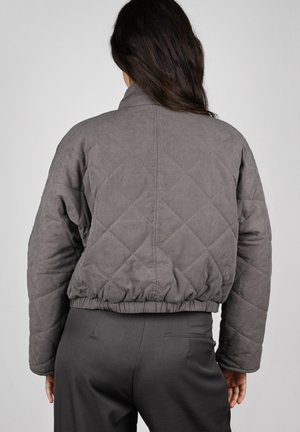 Chaqueta bomber acolchada gris con cuello alto, cinturilla elástica y mangas largas, con una textura suave y patrón de diamantes.