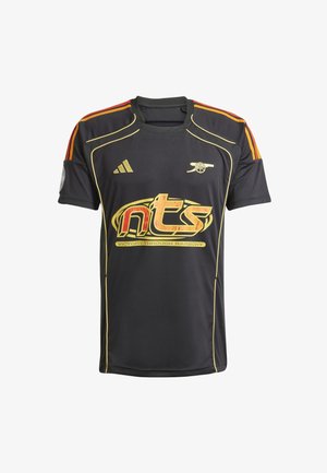 Schwarzes Sporttrikot mit goldenen und roten Akzenten. Enthält das Adidas-Logo auf der rechten Schulter, großen "nts"-Text und Slogan in der Mitte.
