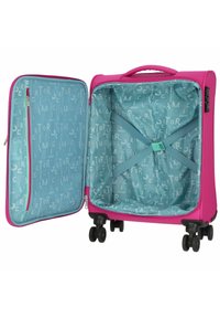 Valigia rigida rosa con un esterno testurizzato, contiene una foderatura azzurro chiaro con un motivo di lettere e una tasca interna in rete. Quattro ruote.