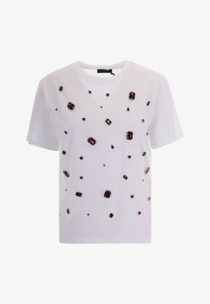 T-shirt bianca a maniche corte decorata con pietre preziose di colore rosso scuro sparse di varie forme e dimensioni.