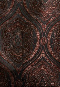 Schwarzer und bronzefarbener Brokatstoff mit einem komplizierten Paisleymuster, das Wirbel und florale Details zeigt und eine strukturierte Oberfläche präsentiert.