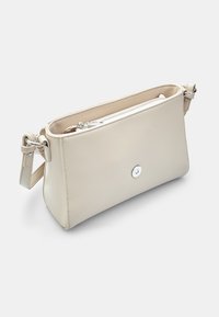 Beige muovi laukku suorakulmaisen muodon, sileän pinnan, ylhäältä avattavan vetoketjun ja hopeisen nappikiinnityksen. Mukana säädettävä olkahihna.