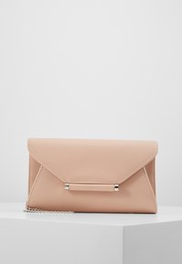 Pochette enveloppe en similicuir pêche avec ferrures argentées et bandoulière chaîne. Texture lisse, design angulaire et fermeture à rabat.