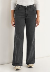 Högmidjade, vida jeans i mörkgrå denim med en slät textur. Har fem fickor och knappstängning fram.
