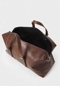 Bolso tote de cuero marrón con herrajes plateados, que presenta un cierre con cremallera y un interior abierto. Superficie texturizada y asas robustas para llevar.