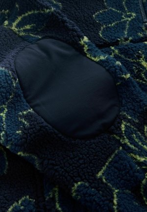 Fleece jacket with a navy base, featuring a textured pattern in green. It has a smooth fabric elbow patch and a zip closure.