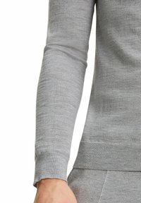 Maglione grigio a maniche lunghe realizzato in tessuto morbido. Presenta un collo e polsini a costine. Texture liscia con un design aderente.
