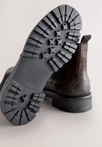 Brauner Leder-Stiefelette mit robustem schwarzem Gummisohlen. Verfügt über Brogue-Details und elastische Seiteneinsätze für eine sichere Passform.