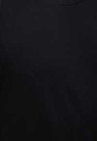 Απλή μαύρη ύφανση με διακριτική υφή και εμφανείς ραφές κοντά στο πάνω κέντρο.