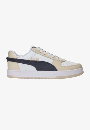 Witte en beige sneaker met een donkerblauwe zijstreep, gestructureerd leer, ronde neus, platte veters en een rubberen loopzool. Geregeld met branding.