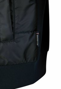 Zwarte pufferjack met een gladde, glanzende stof en ribgebreide accenten. Een klein "HECHTER" label is zichtbaar op de zijnaad.