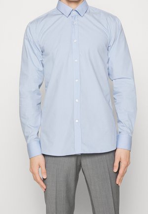Lichtblauw overhemd met een standaardkraag, lange mouwen en een gladde, licht glanzende textuur. Heeft witte knopen aan de voorkant.