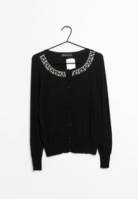 Svart kofta med rund halsringning, utsmyckad med pärlkrage, långa ärmar och framknäppning. Mjuk textur med ribbade muddar.