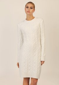 Weißes Strickkleid mit einem strukturierten Rautenmuster aus Zopfstrick, gerippten Bündchen und Ausschnitt sowie einer geraden Silhouette.