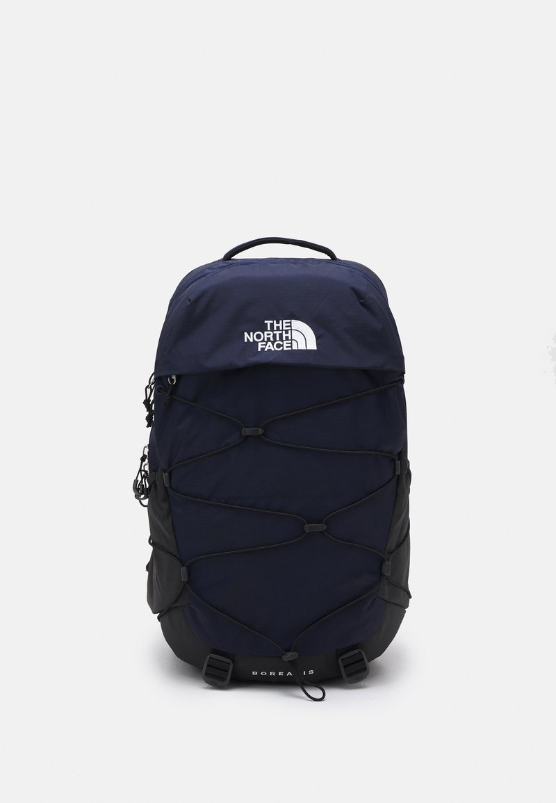 Zaino blu navy con accenti neri, dotato di un sistema a corda bungee, manico superiore e logo frontale. Realizzato in tessuto resistente, design strutturato.