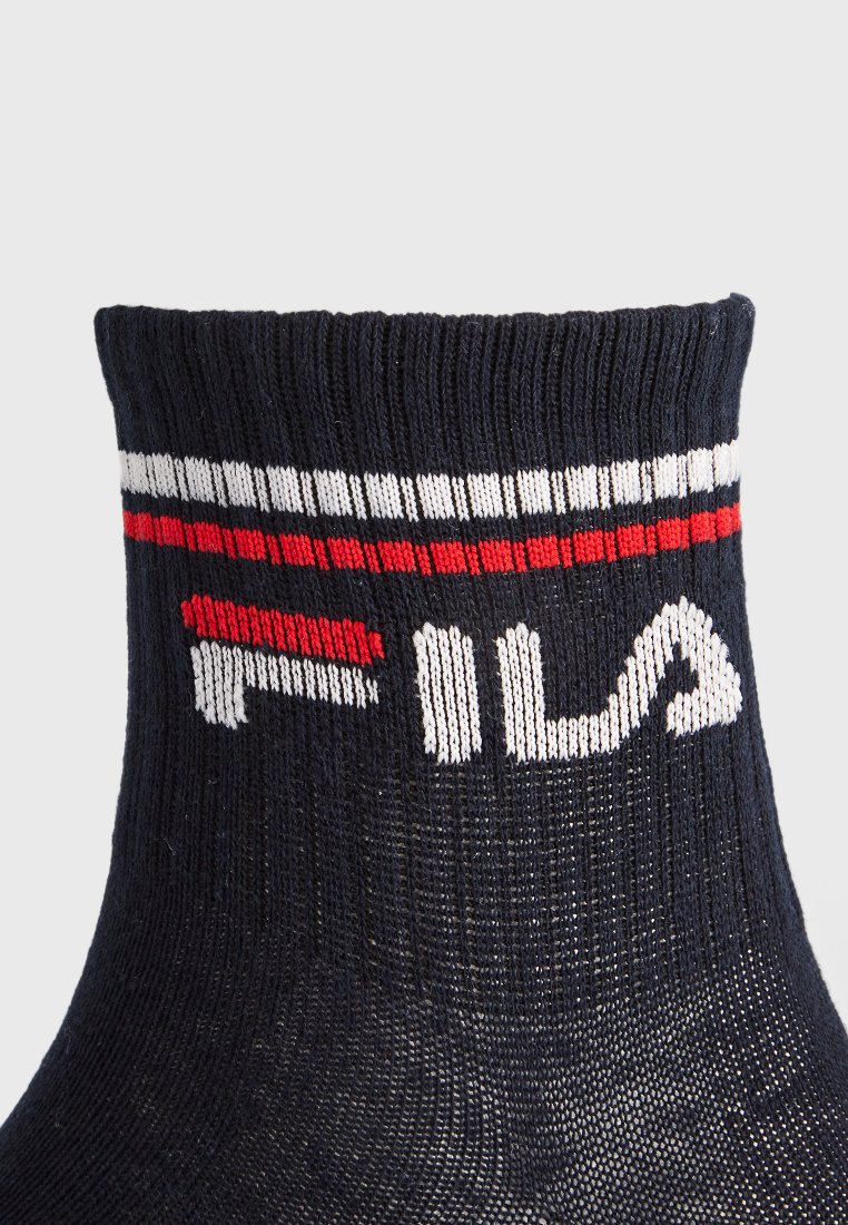 Granatowe bawełniane skarpetki kostkowe z prążkowanym mankietem, czerwono-białe poziome paski oraz duże białe logo "FILA" z boku.