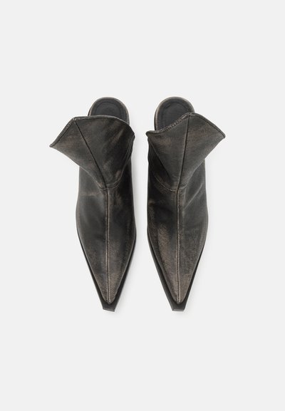 Mules pointus en cuir noir avec un design unique replié à l'ouverture. Présente une texture lisse et une silhouette élégante.
