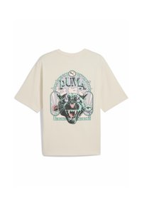 Beige bomulds t-shirt med et sort panther grafik med farverige accenter og teksten "PUMA" i fed skrift. Kortærmet og afslappet pasform.