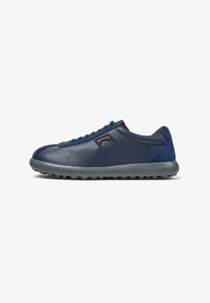 Granatowe skórzane sneakersy z zamszowymi akcentami, szara gumowa podeszwa, zaokrąglony kształt i minimalistyczny design sznurowania. Zawierają subtelny detal logo po boku.