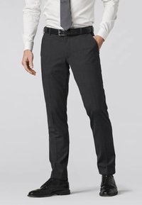 Pantaloni grigi su misura con una vestibilità slim, caratterizzati da una parte frontale piatta, tasche laterali e una texture liscia, abbinati a scarpe eleganti nere.