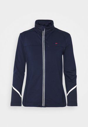 Veste bleu marine zippée intégrale avec col montant, bordure de fermeture éclair blanche et détails réfléchissants blancs sur les manches et la poitrine.