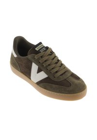 Chaussure en velours côtelé et suède marron avec des accents blancs et une semelle en caoutchouc ; présente un dessus texturé, un bout rond et un système de laçage.