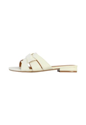 Sandalini bianchi con tre fascette incrociate, suola piatta e tacco basso. Texture liscia con design minimalista.