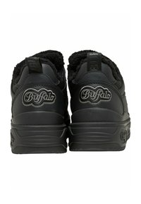 Paire de baskets noires de la marque Buffalo vues de dos, avec des semelles épaisses et des cols rembourrés et doux.