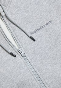 Light gray zip-up hoodie made of soft fabric, featuring a white zipper, gray drawstrings, and embroidered "Peak Performance" logo.