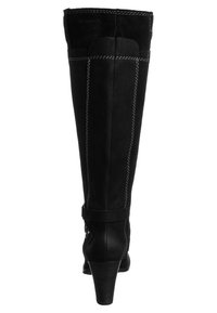 Botas de tacón alto negras, hechas de cuero suave y gamuza, con un diseño ajustado, costuras en contraste y un acento de correa cerca del tobillo.