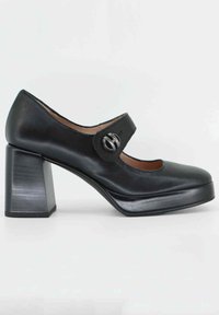Scarpe Mary Jane in pelle nera con punta arrotondata, cinturino largo con fibbia circolare e tacco quadrato spesso. Trama liscia e design elegante.