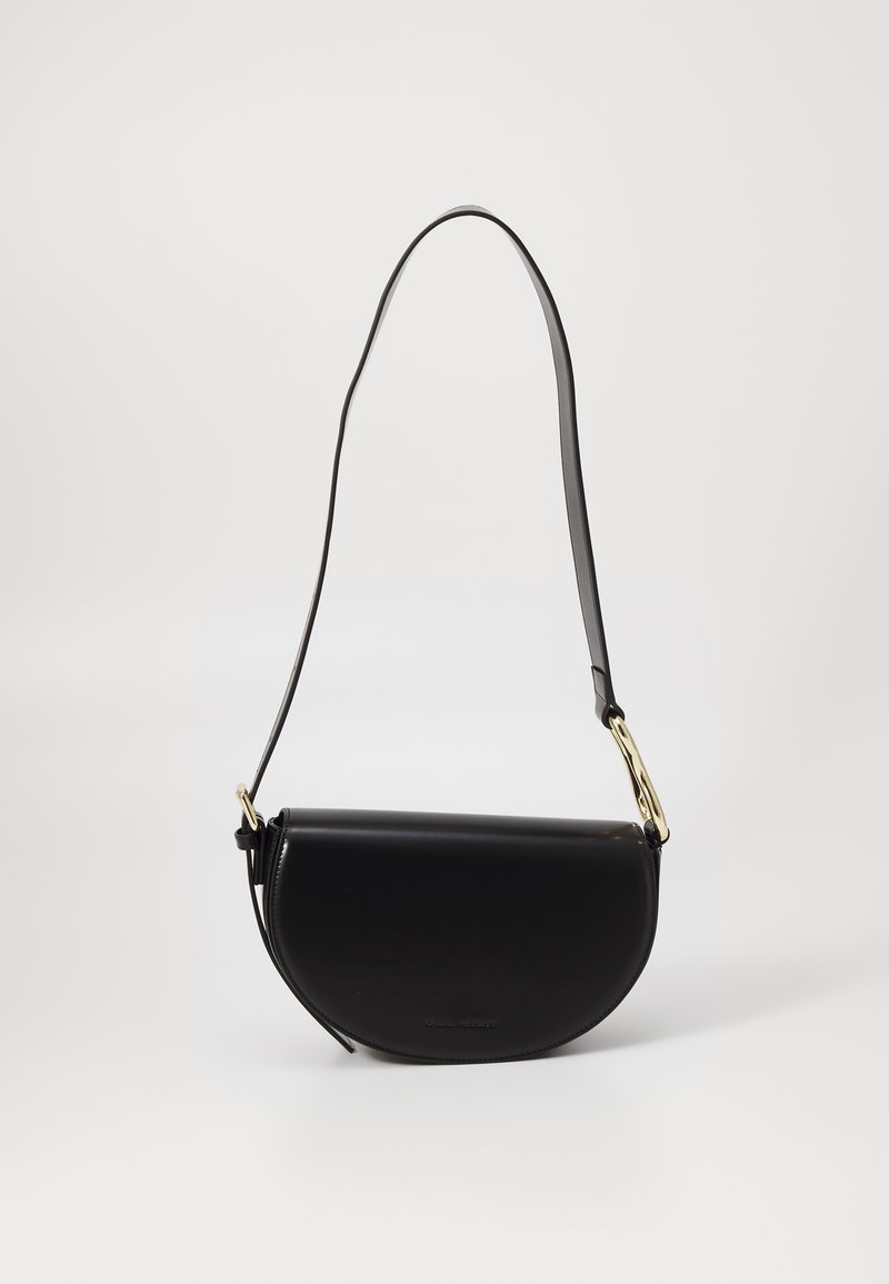 Sort halvmåneformet læder crossbody taske med justerbar rem og spænde i guld-tone metal på ensfarvet hvid baggrund.