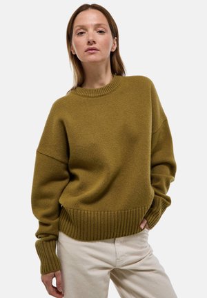 Pull en tricot vert olive avec un col rond et un ourlet en côtes. Présente des épaules tombantes et des manches longues avec des poignets en côtes.