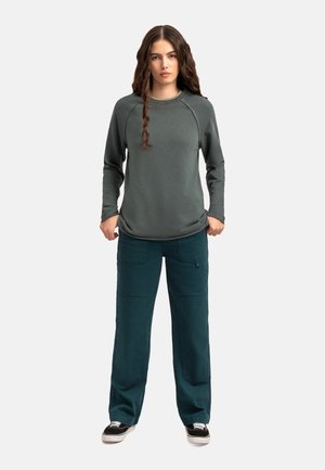 Sweat-shirt vert à manches longues avec col rond et manches raglan, associé à un pantalon cargo en teal avec poches et coupe décontractée.