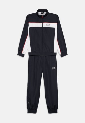 Zwart-wit EA7 trainingspak met rode bies, jas met rits, elastische manchetten en bijpassende broek met elastische enkels en EA7-logo's.