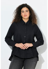 Black button-up shirt with long sleeves, ruffled hem, and a collar. Made from a smooth fabric, styled with a relaxed fit.