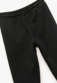 Schwarze Jogginghosen aus weichem Material mit einem elastischen Bund, Kordelzug und Seitennähten für eine entspannte Passform.