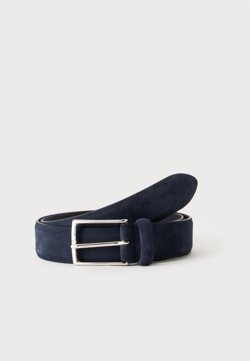 Ceinture en daim bleu marine roulée avec une boucle rectangulaire argentée sur un fond clair uni.