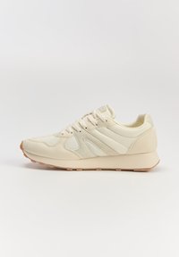 Beżowe buty sportowe z połączeniem zamszu i siateczki, z wyściełanym kołnierzem, trzema paskami oraz gumową podeszwą.