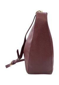 Borsa in pelle bordeaux con superficie texturizzata, forma angolare, tracolla regolabile e dettagli in oro sulla zip.