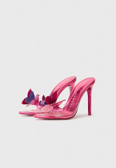 Rosa High-Heels mit klarem Riemen, geschmückt mit jeweils drei bunten Schmetterlingsverzierungen auf jedem Schuh.