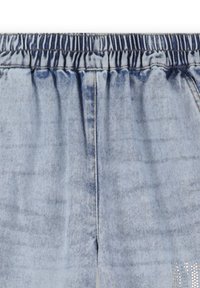 Shorts en denim bleu clair avec une taille élastique, présentant une légère décoloration et des détails embellis sur le bas. Texture douce, design décontracté.
