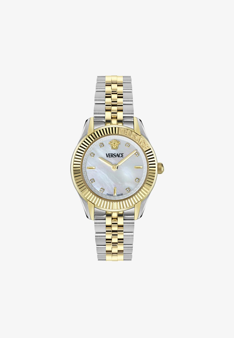 Reloj de metal dorado y plateado con una esfera redonda de nácar blanco, marcadores de hora de diamante y un bisel dorado estriado. "Versace" grabado en el lateral.