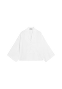 Biała, długosleeve bluzka w stylu kimono z szerokimi rękawami i głębokim dekoltem w kształcie V, zdobiona trzema białymi guzikami.