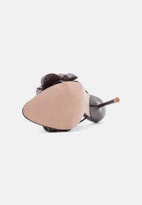 Brun høyhælte sko med spiss tå, teksturert brun såle og en blomstert detalj bak. Materialet ser blankt og glatt ut.