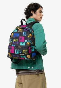 Černý batoh s živými potisky v žluté, modré, růžové a tyrkysové barvě. Nastavitelné popruhy a logo na přední straně.