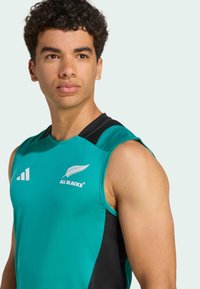 Turkusowy bezrękawnik sportowy z czarnymi akcentami, z logo All Blacks oraz paskami Adidas. Gładka faktura, sportowy krój.