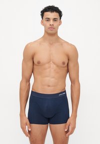 Marineblaue Baumwollboxershorts mit einem elastischen Bund und einem Logo. Glatte Textur, enganliegendes Design mit einem mittelhohen Schnitt.