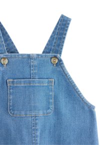 Denim sal op is lichtblauw, met verstelbare banden, twee knopen en een zak aan de voorkant. De stiksels zijn zichtbaar langs de randen.